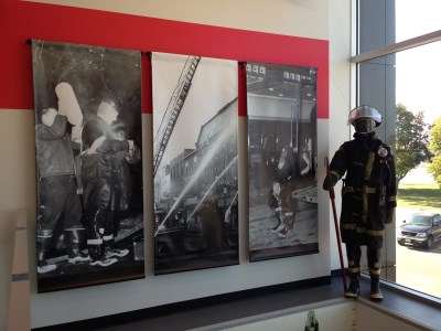 Firefighter mannequin standing with historic photos of firefighting in Belleville