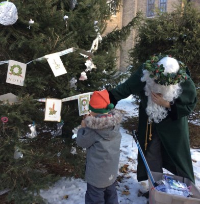 Father Christmas decorating tree with child