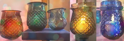 A row of five fairy lamps, small votive candle holders, in assorted colours of red, green, amber and colbalt blue