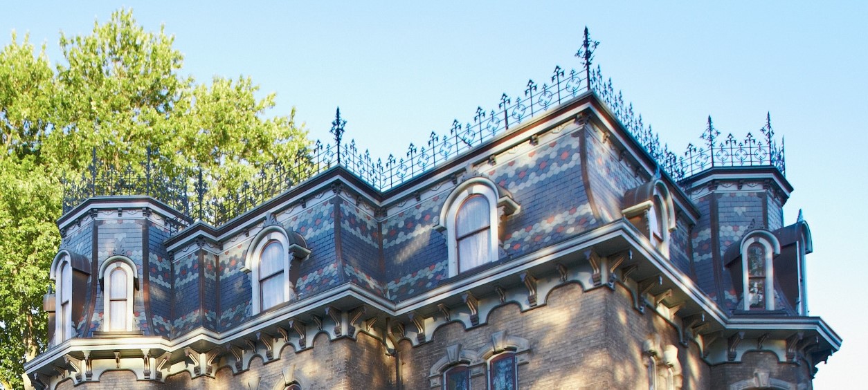 Glanmore's mansard roofline features multi-coloured slates in grey, red and green arranged in a rosette pattern. Elaborate cast-iron cresting accentuates the rooftop.  