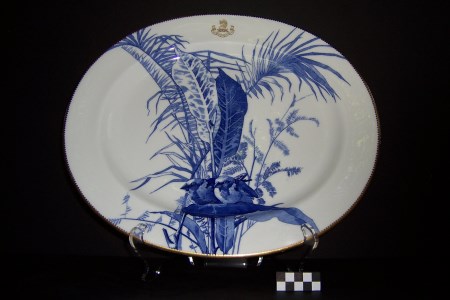 Blue and white platter with a gold-coloured insignia at the top rim.